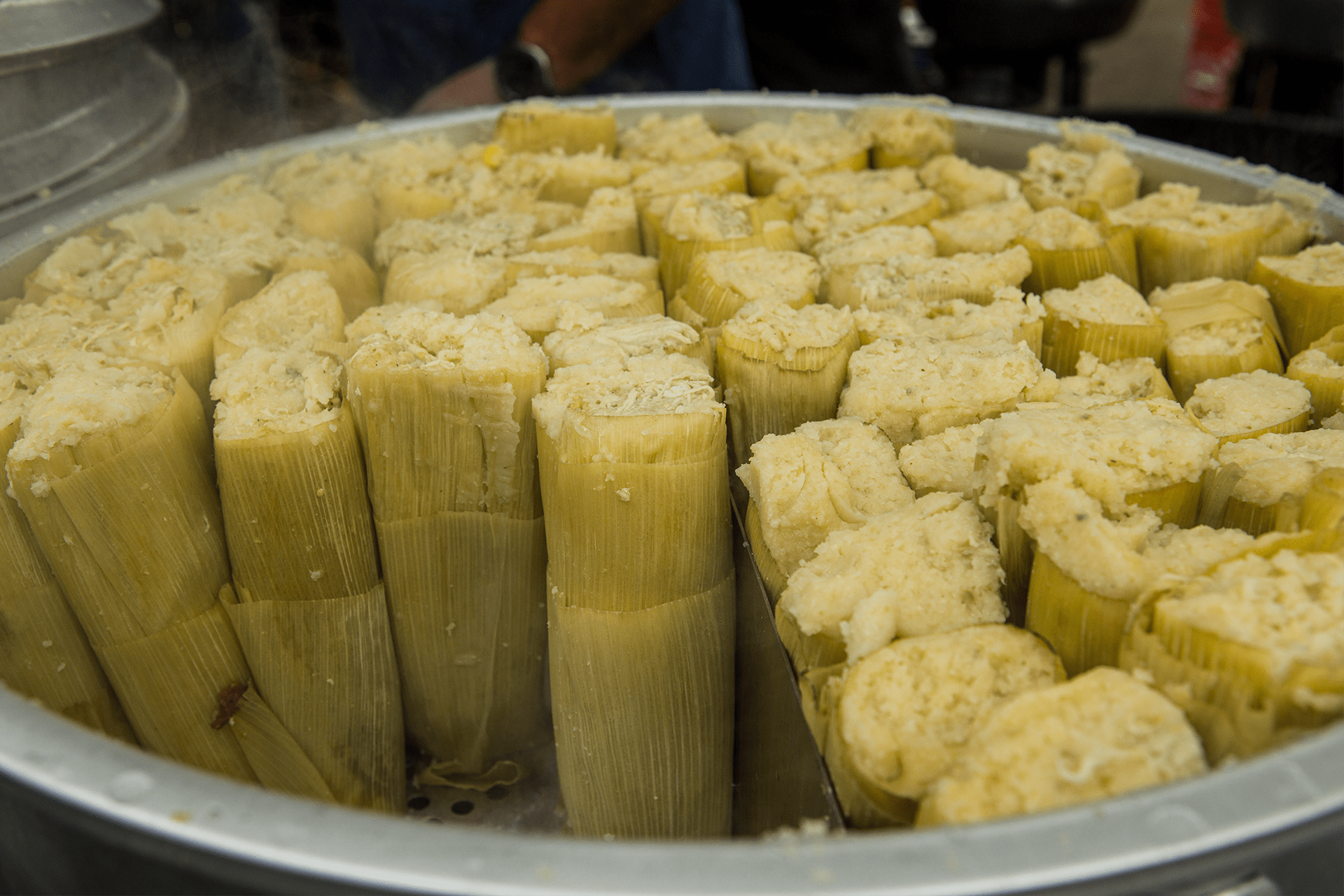 Image of numerous tamales stacked in a pot.